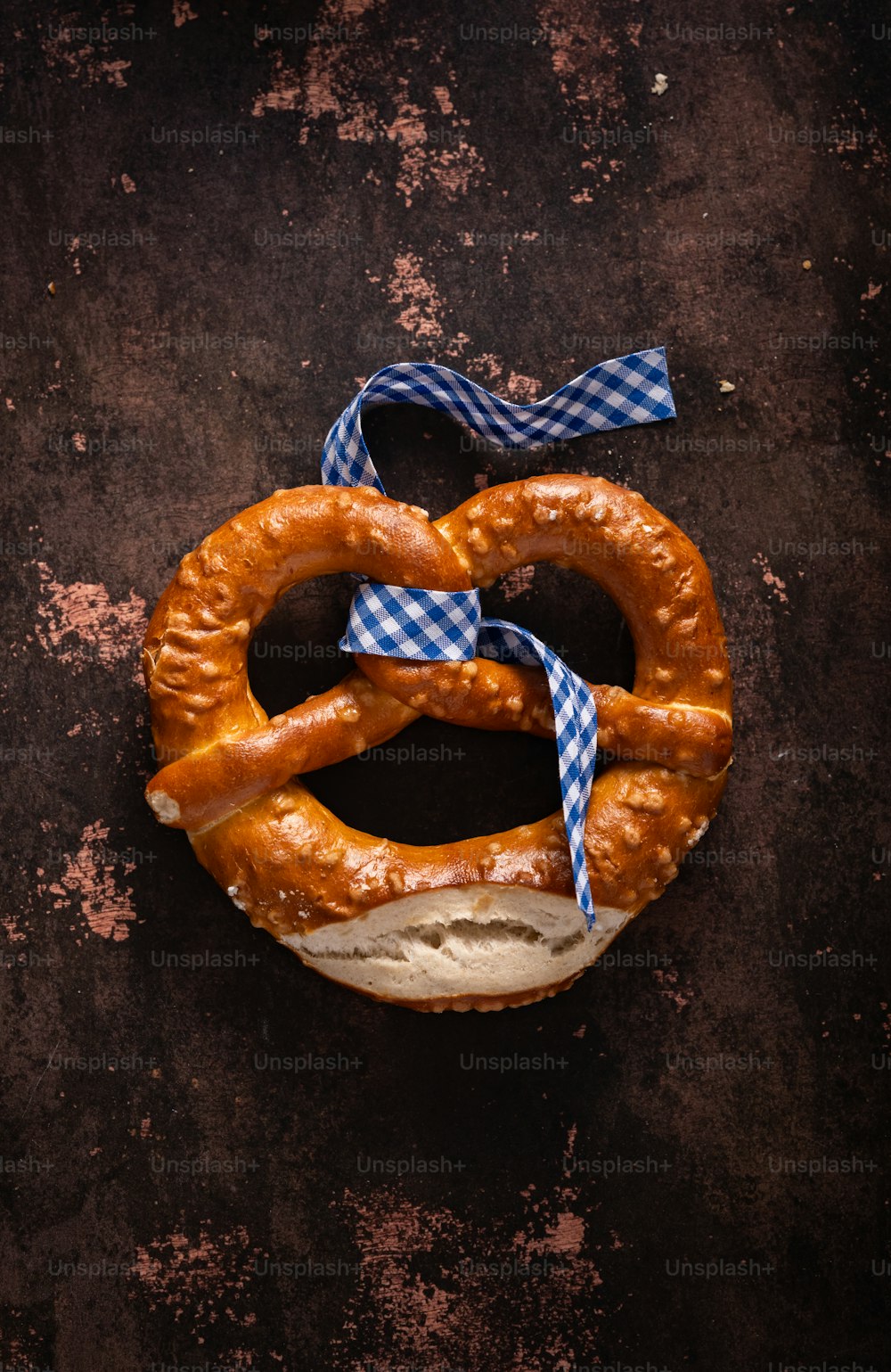 a pretzel on a bun with a blue ribbon