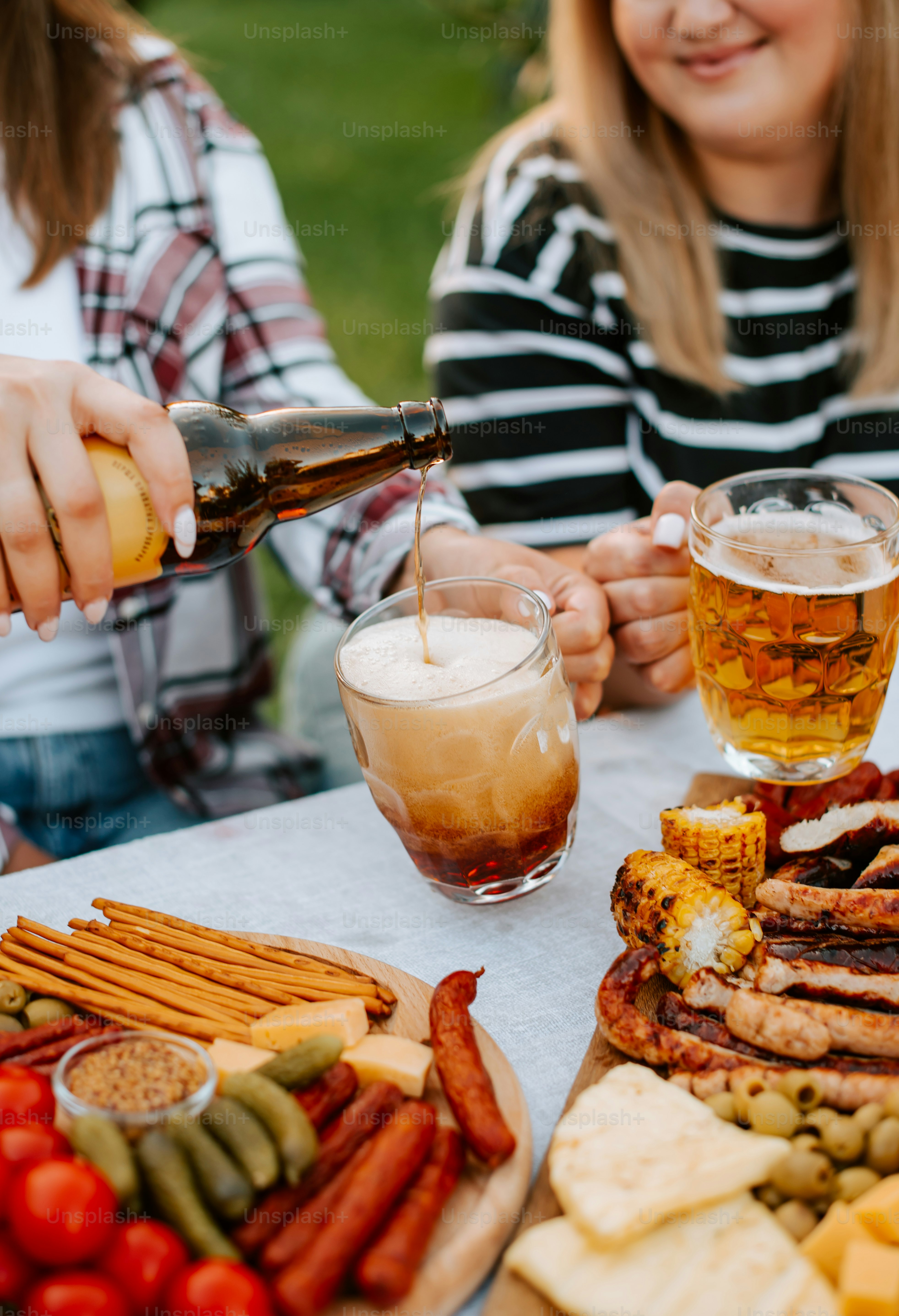 A group of people sitting around a table with food and drinks photo ...