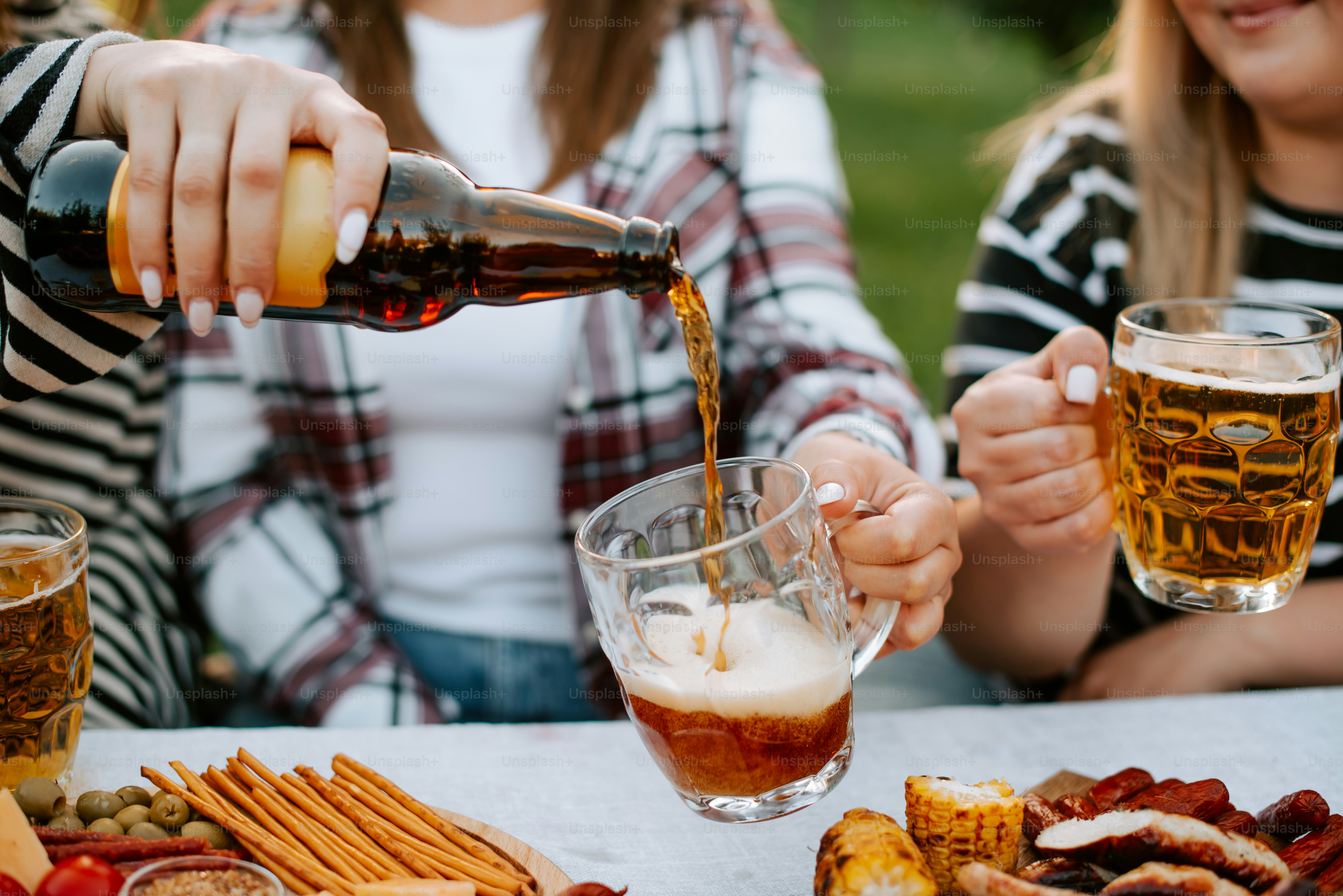A group of people sitting around a table with food and drinks photo ...