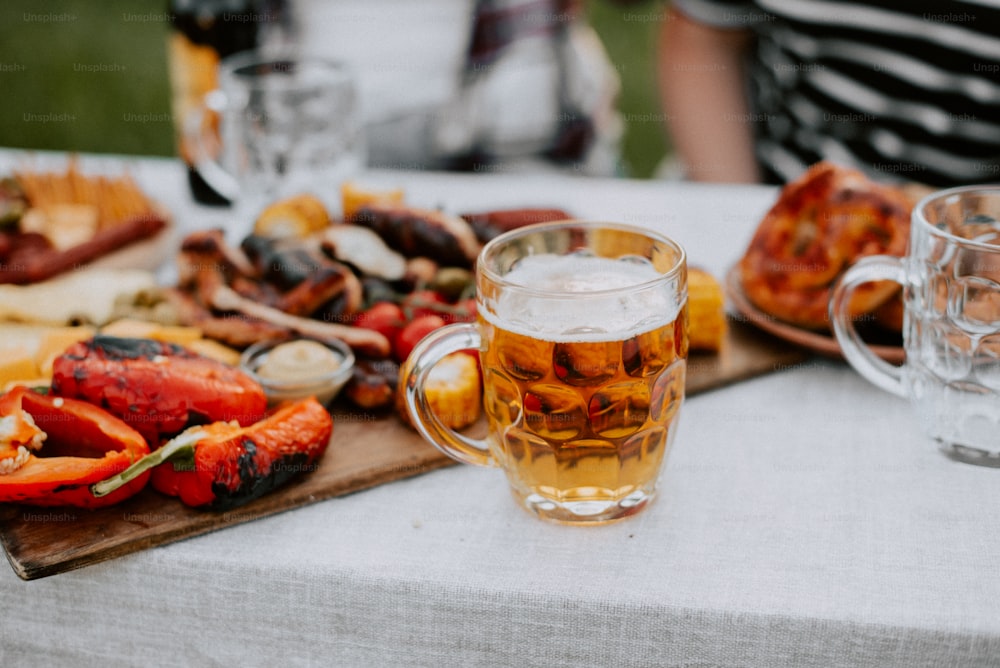 a table topped with a tray of food and a mug of beer