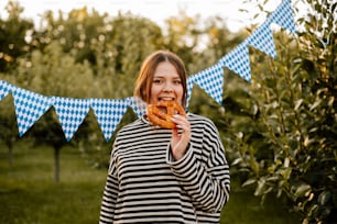 Una mujer está comiendo una rosquilla en un campo