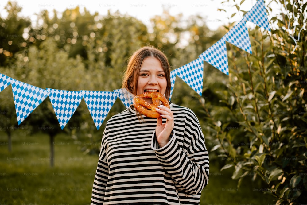 a woman is eating a donut in a field