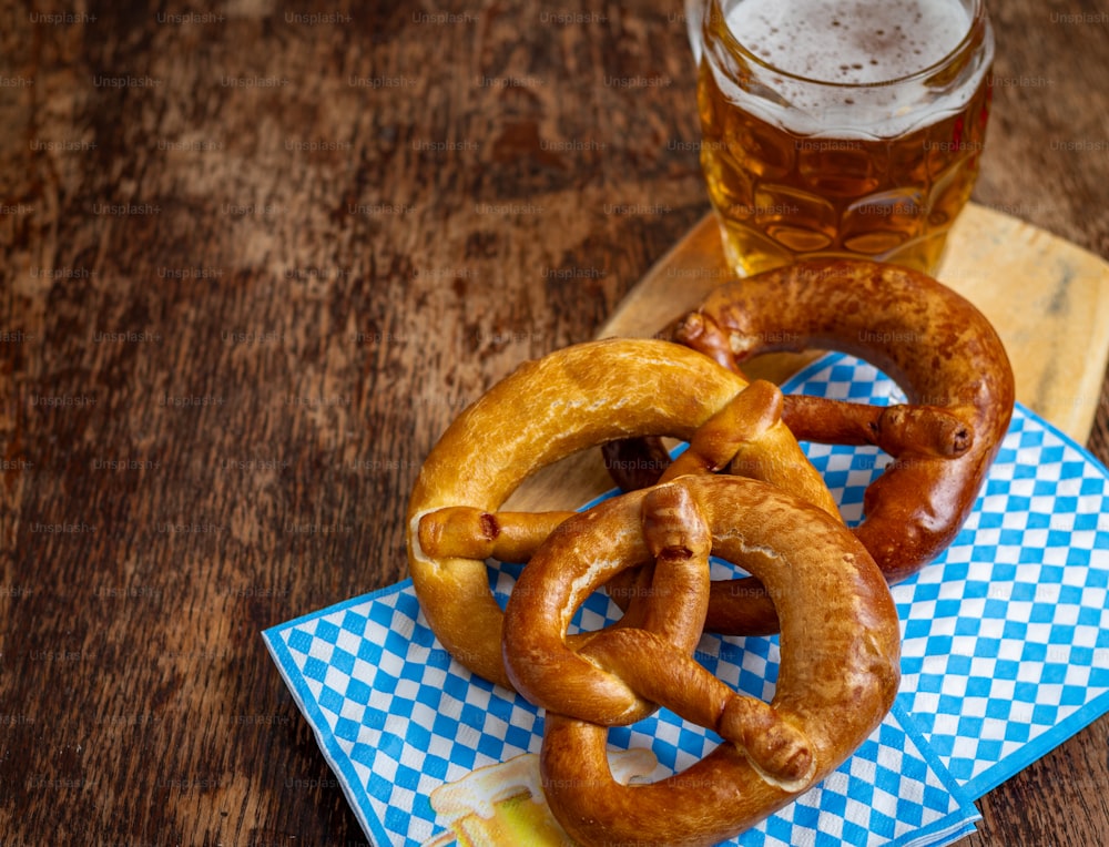 two pretzels and a glass of beer on a table