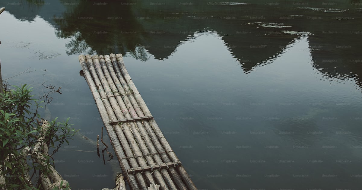 A wooden raft floating on top of a river photo – Guangxi Image on Unsplash