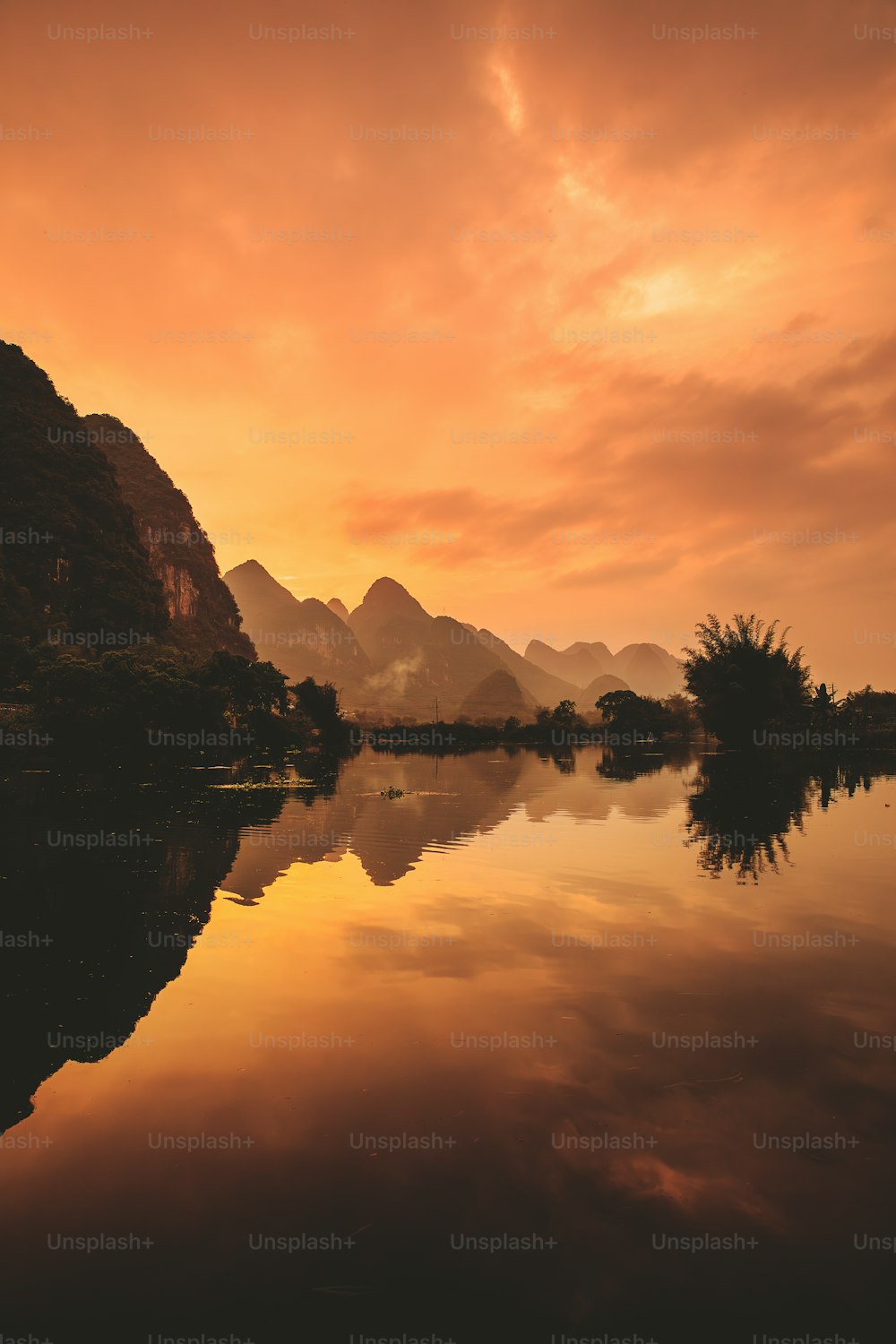 Un lac avec des montagnes en arrière-plan au coucher du soleil