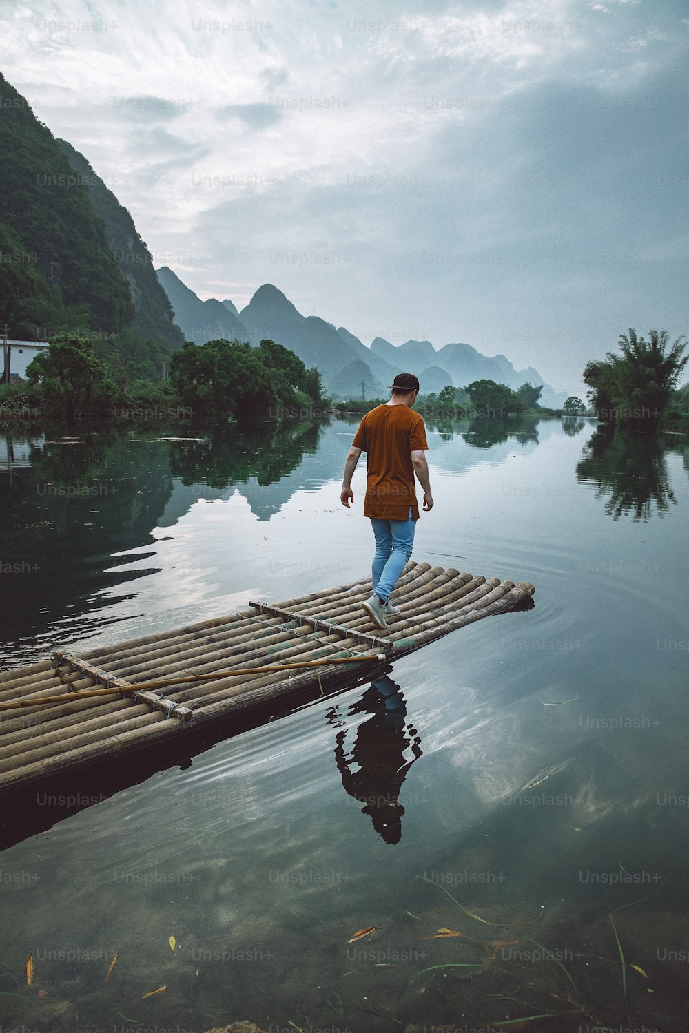 a man walking across a wooden raft across a river