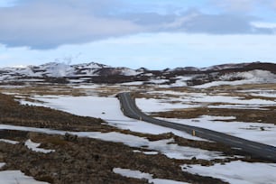 a road in the middle of a snowy field