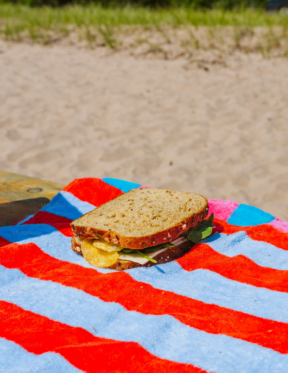 a sandwich sitting on top of a red, white and blue towel