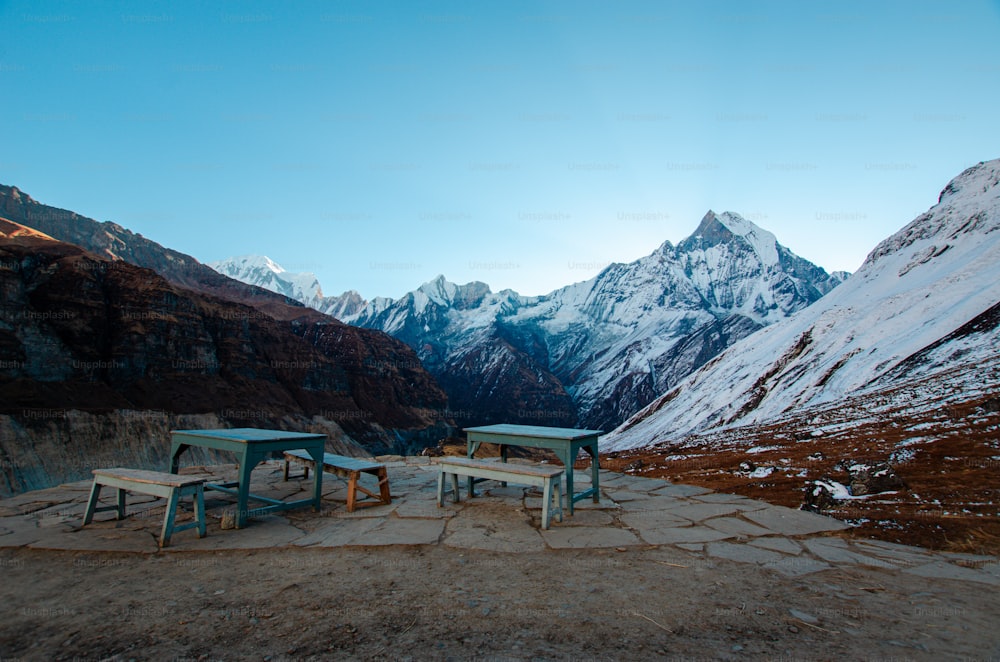 a couple of picnic tables sitting on top of a mountain