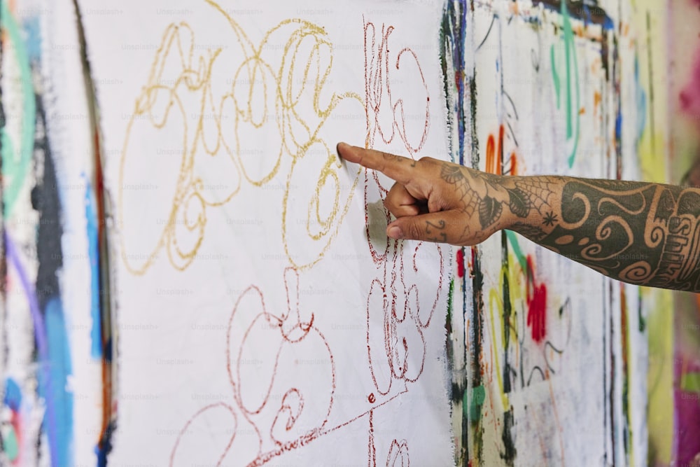 a person pointing at a wall with writing on it