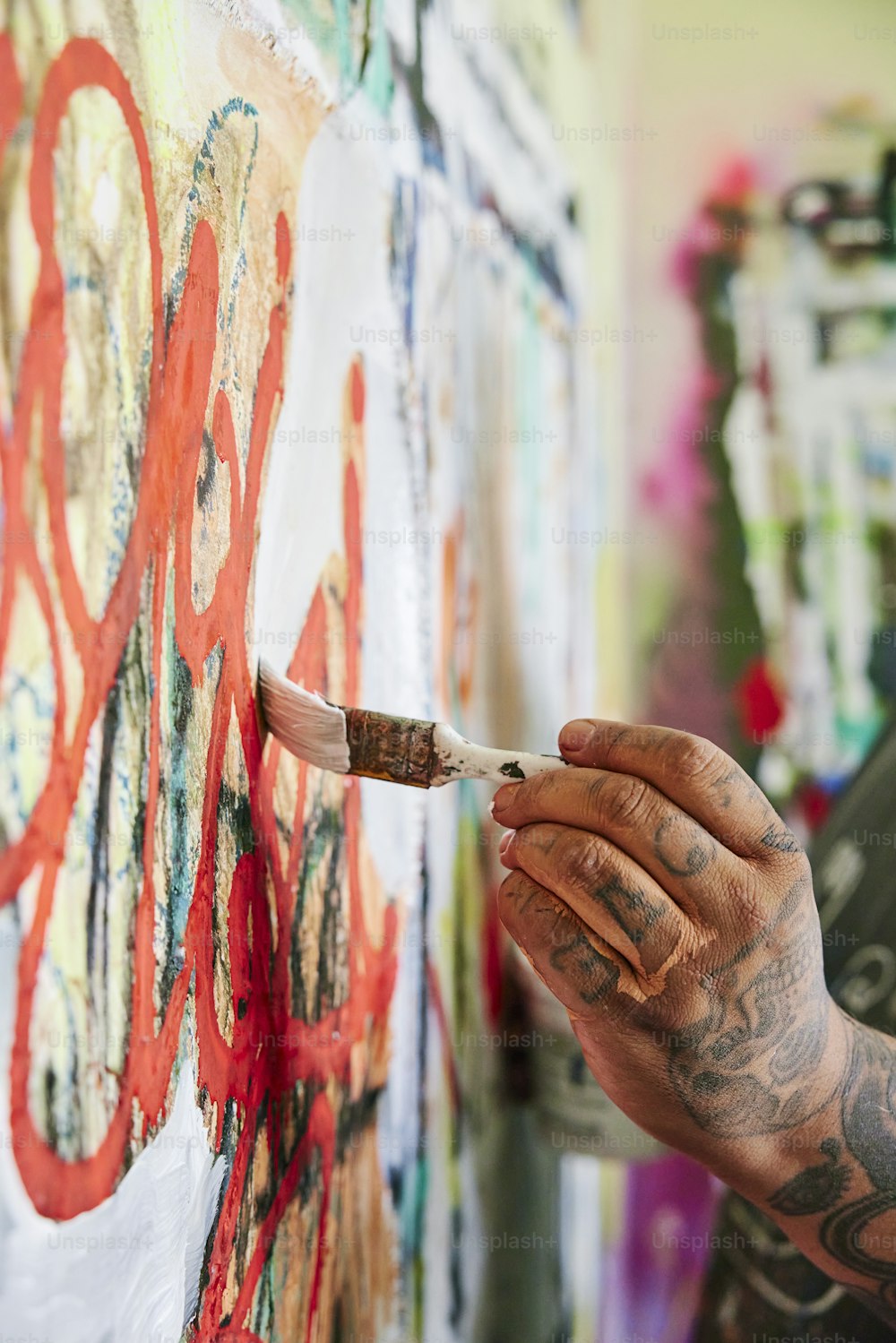 a man holding a paintbrush and painting on a wall