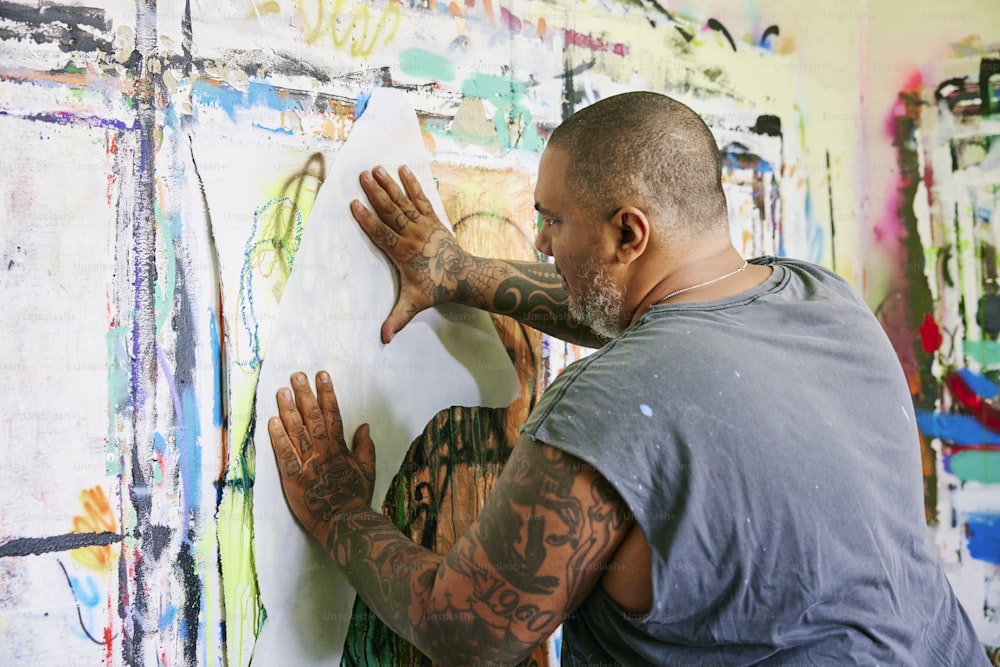 Un hombre está pintando en una pared con sus manos