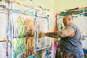 Ein Mann, der mit viel Farbe an einer Wand malt