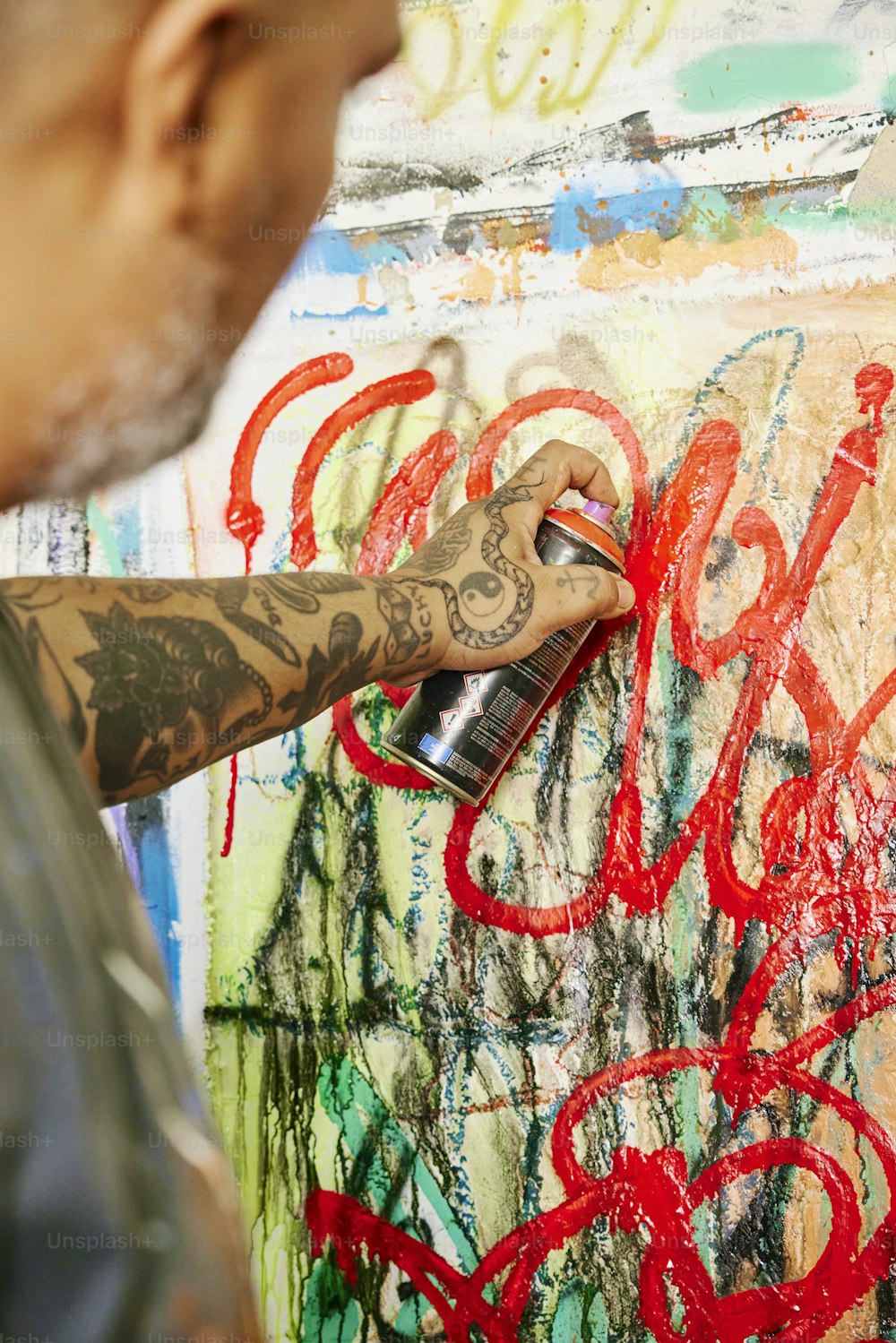 Un homme peint des graffitis sur un mur