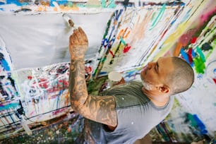 a man is painting on a wall with lots of paint