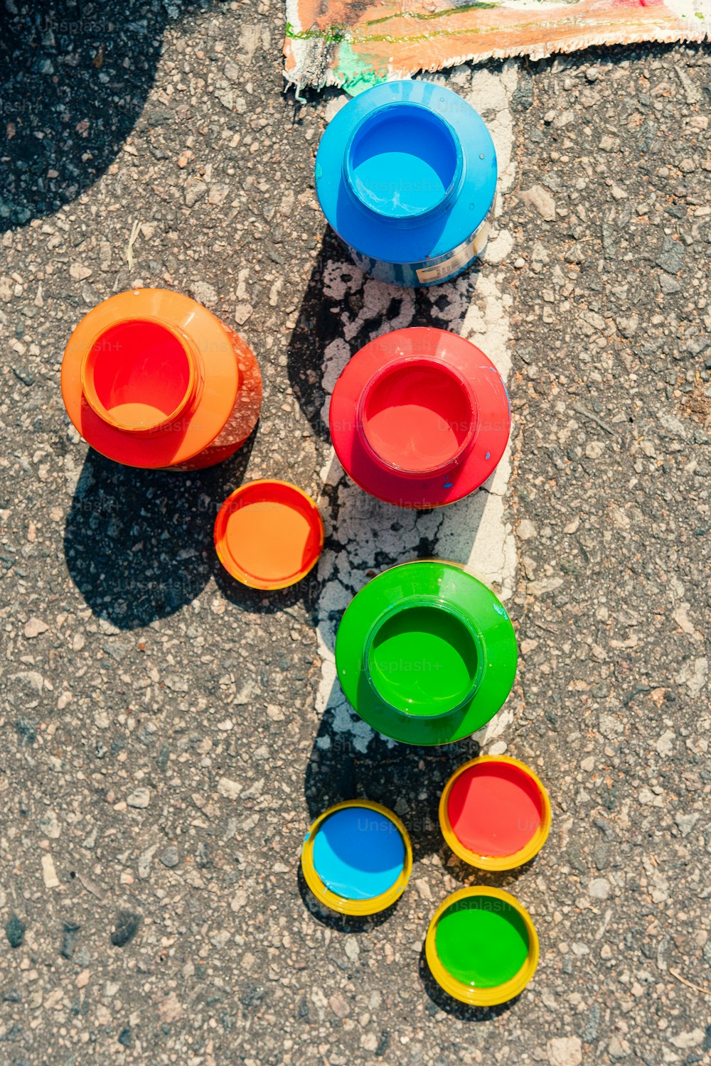 a group of colorful cups sitting on top of a sidewalk