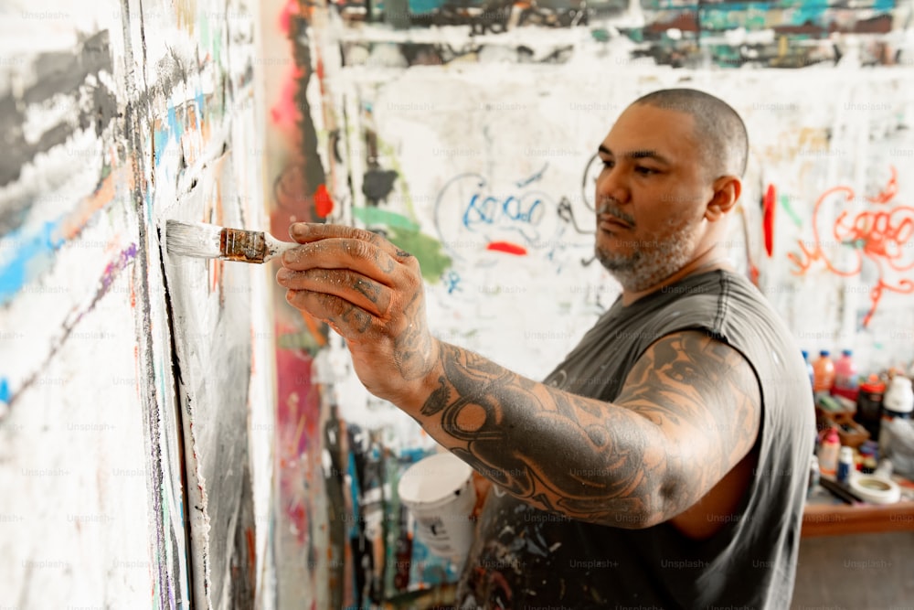 um homem pintando em uma parede com muitos grafites