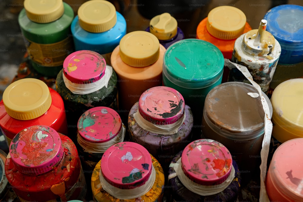 un tas de bouteilles de peinture de différentes couleurs assises les unes à côté des autres