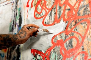 a person is painting on a wall with red paint