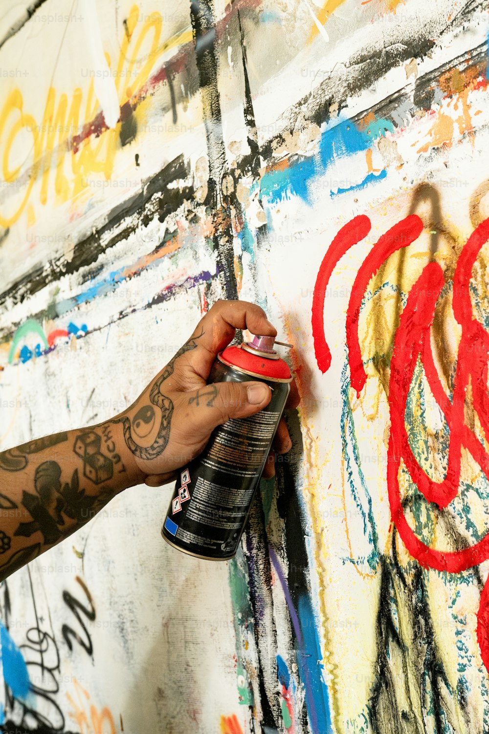 a person spray painting on a wall with graffiti