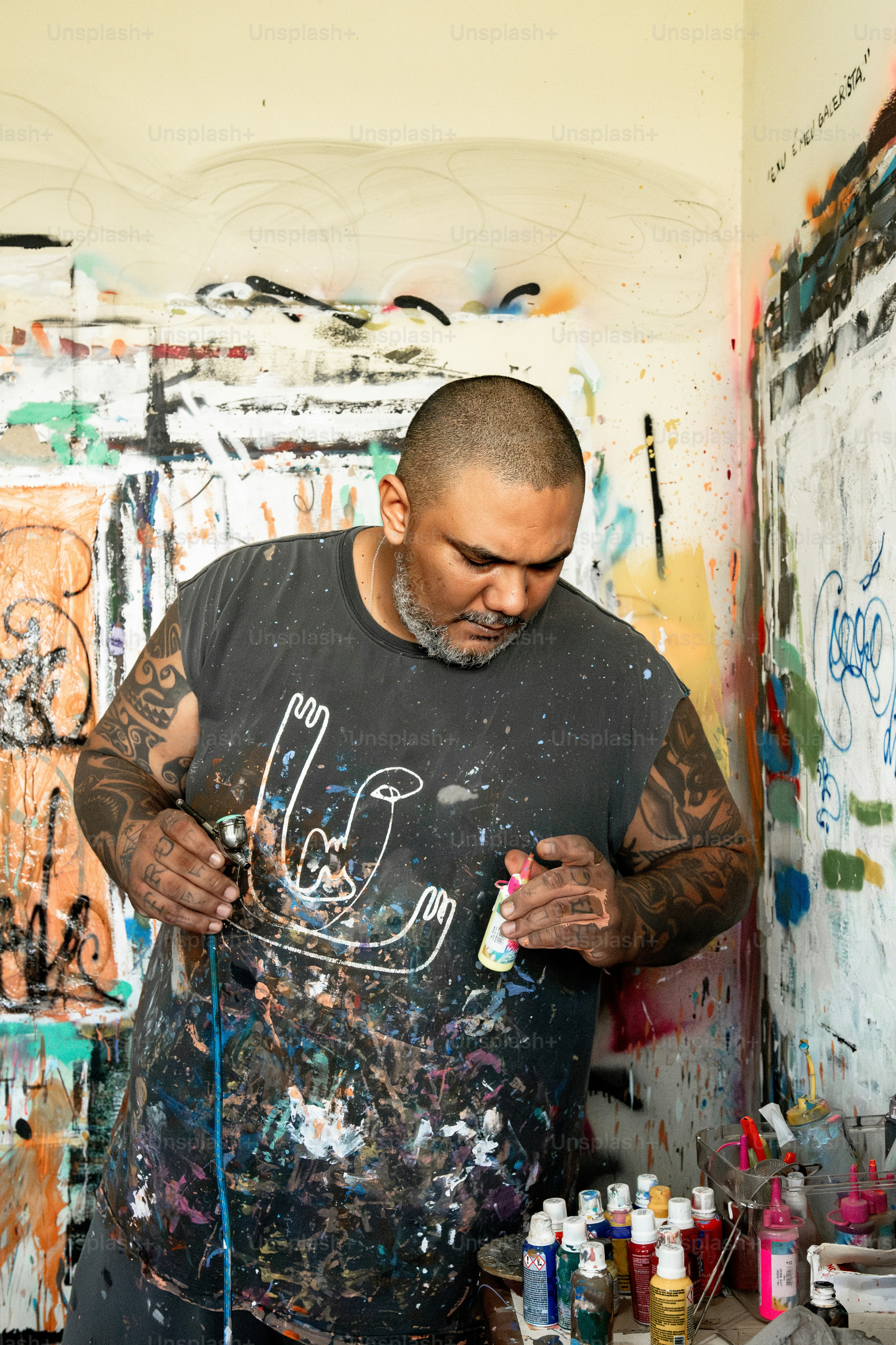 A person spray painting on a wall with graffiti photo – Texture Image ...