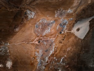 uma vista aérea de um campo de terra com rochas azuis
