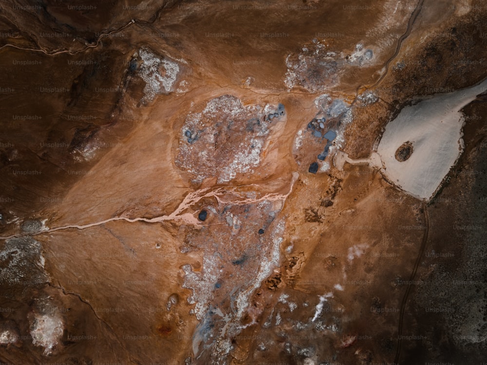 an aerial view of a dirt field with blue rocks