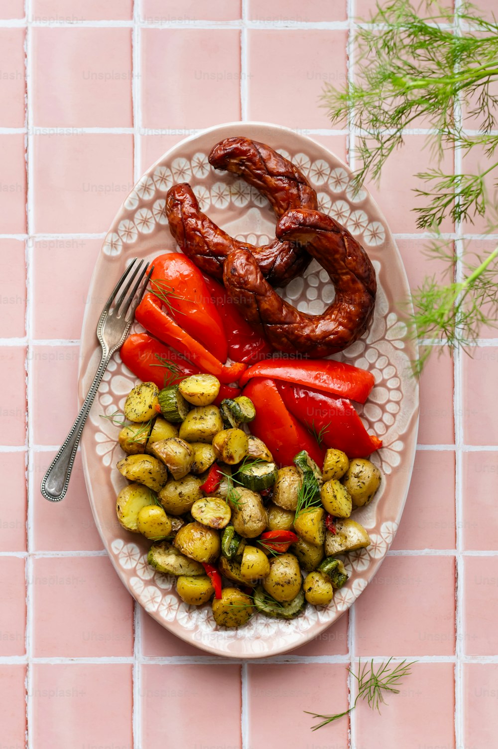 a white plate topped with vegetables and a pretzel