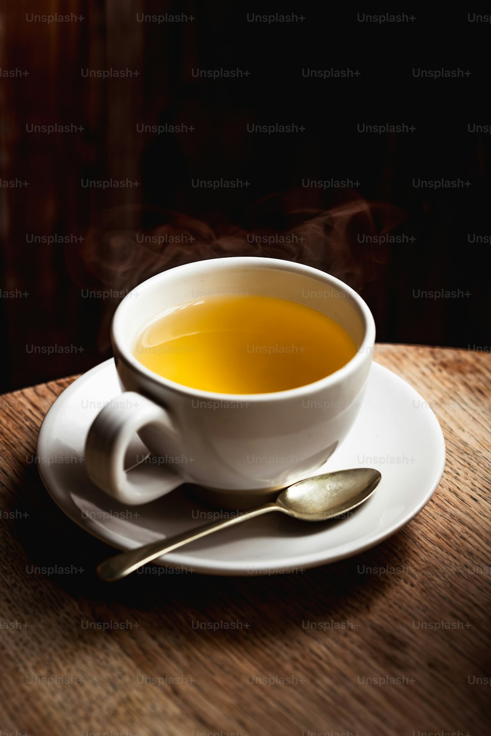 eine Tasse Tee auf einer Untertasse mit einem Löffel
