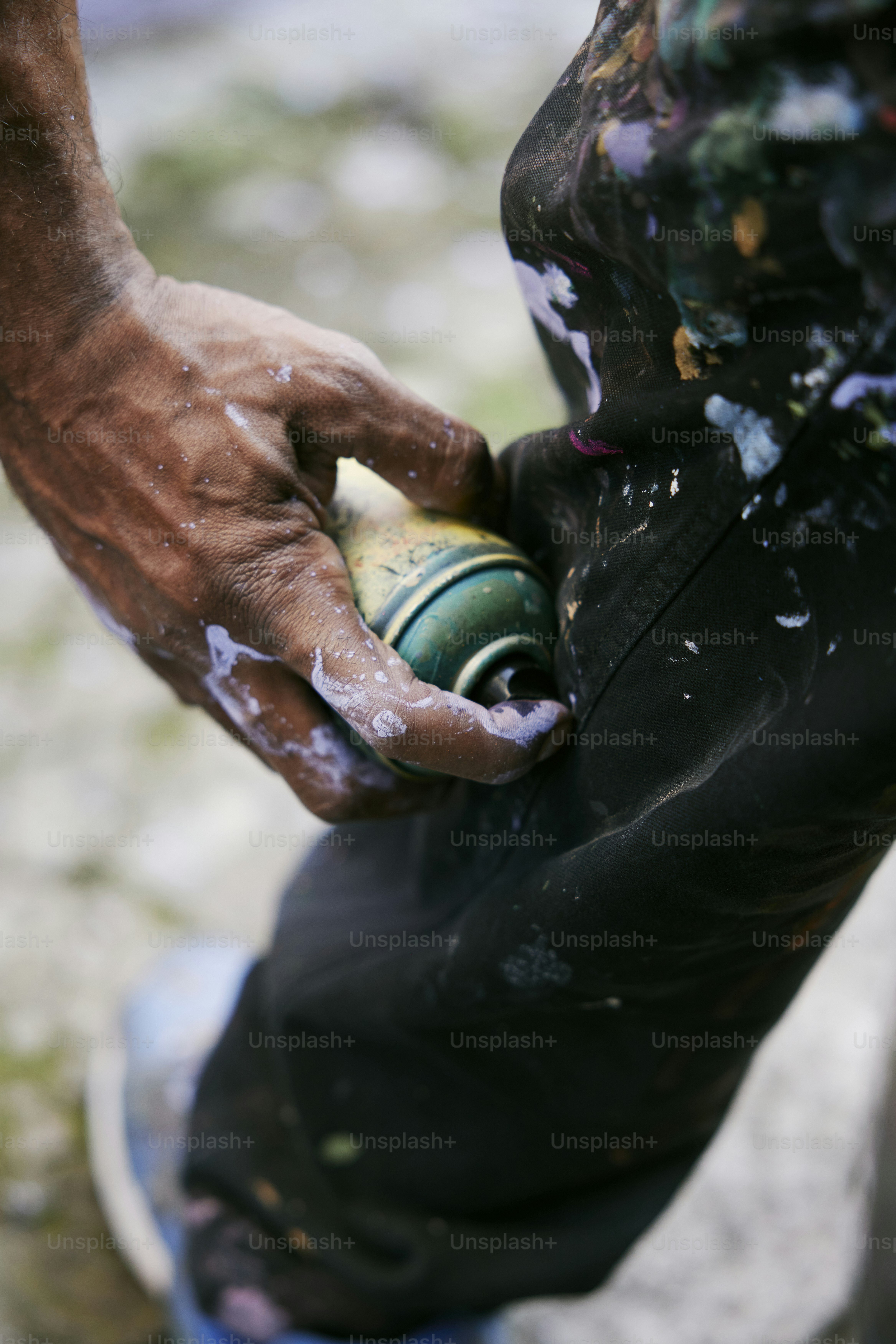 une personne tenant une bouteille de peinture sur une planche à roulettes