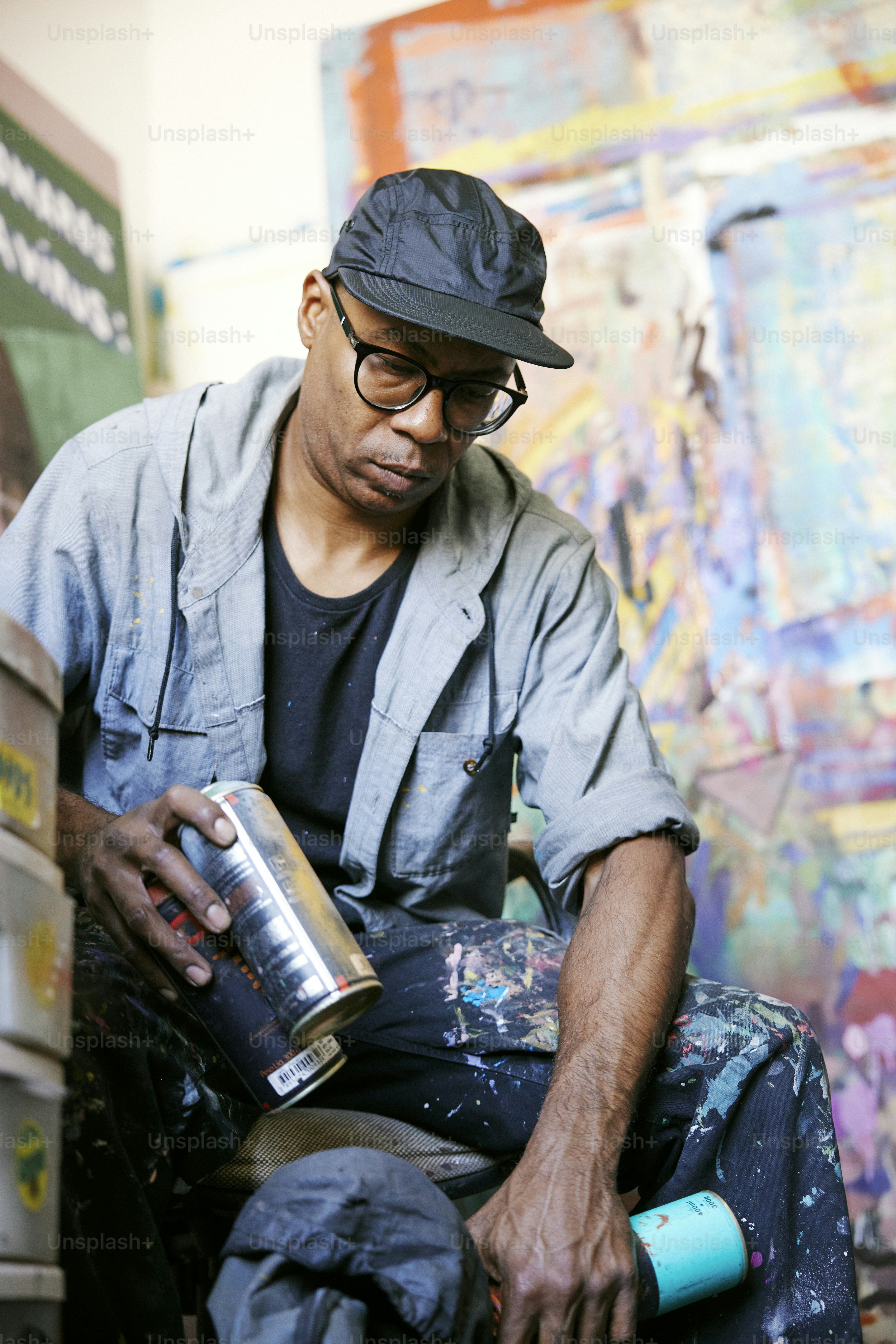 a man sitting on a chair holding a can of paint