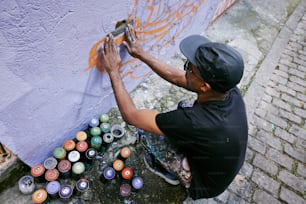 a man is painting a wall with cans of paint