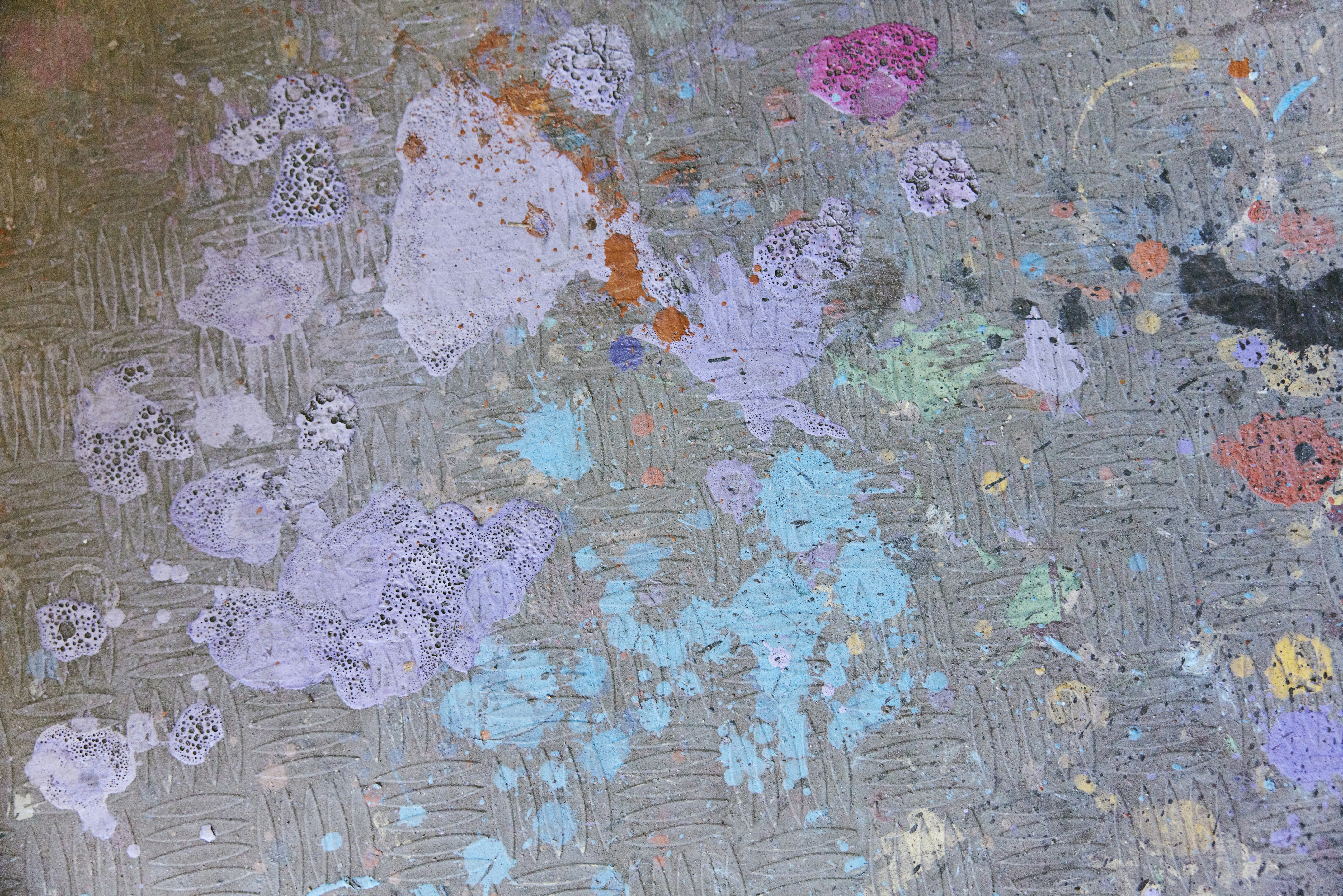 a close up of a piece of art with paint splattered on it