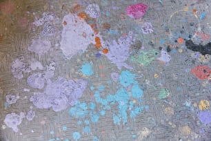 a close up of a piece of art with paint splattered on it