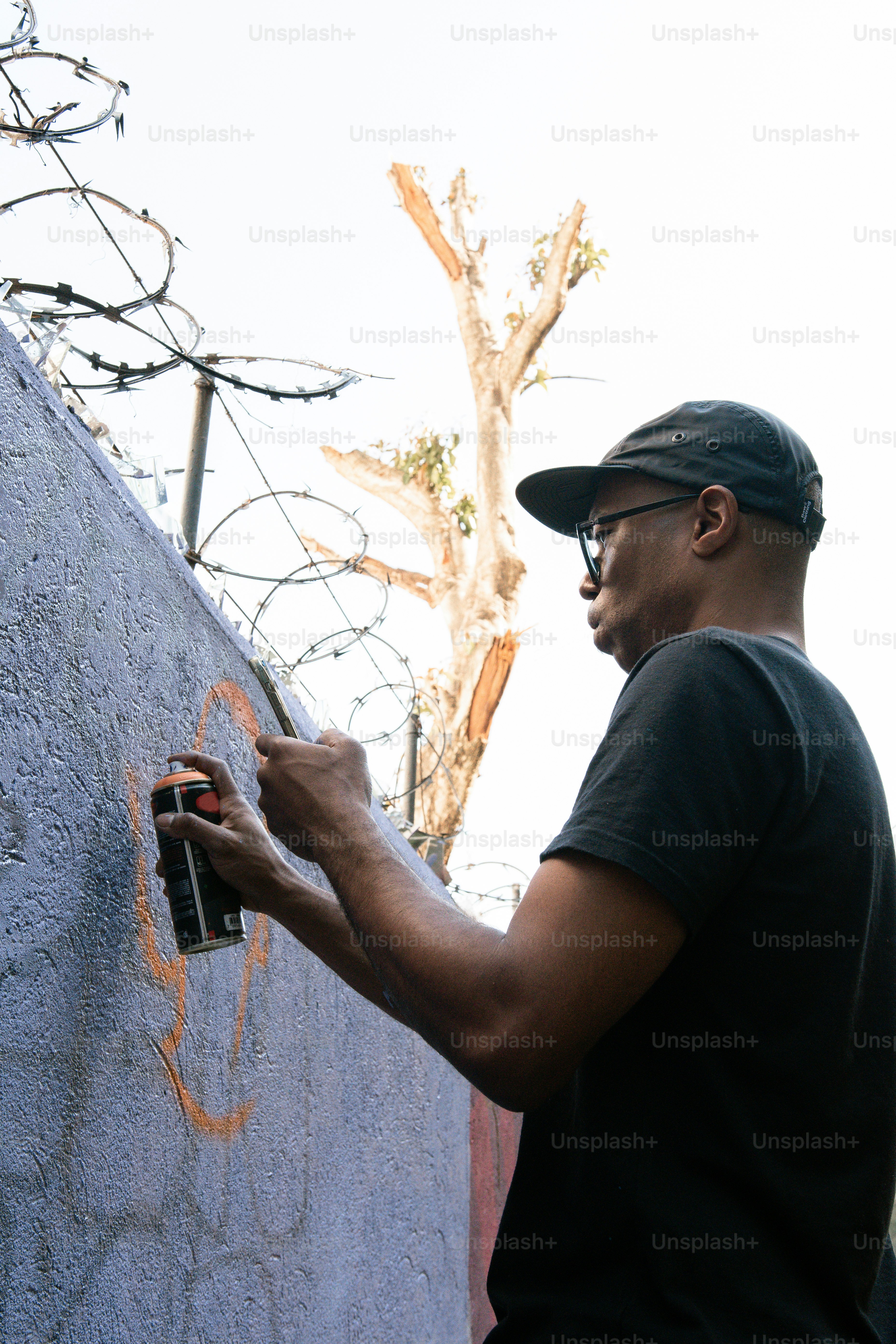 a man painting a wall with graffiti on it