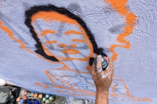 Un homme peint une peinture murale sur un mur