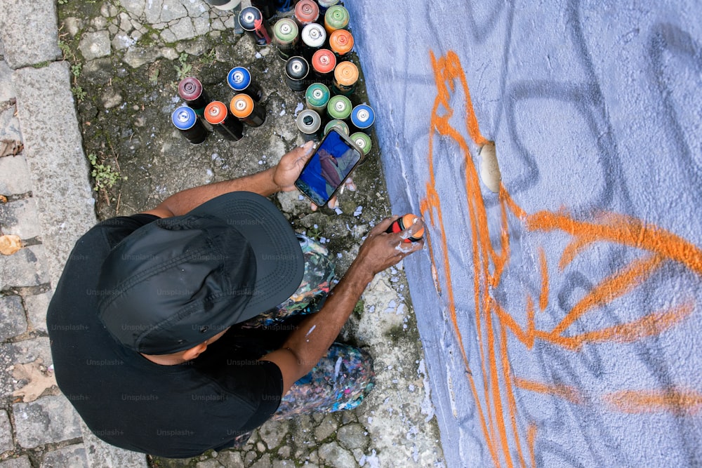 a man sitting on the ground using a cell phone