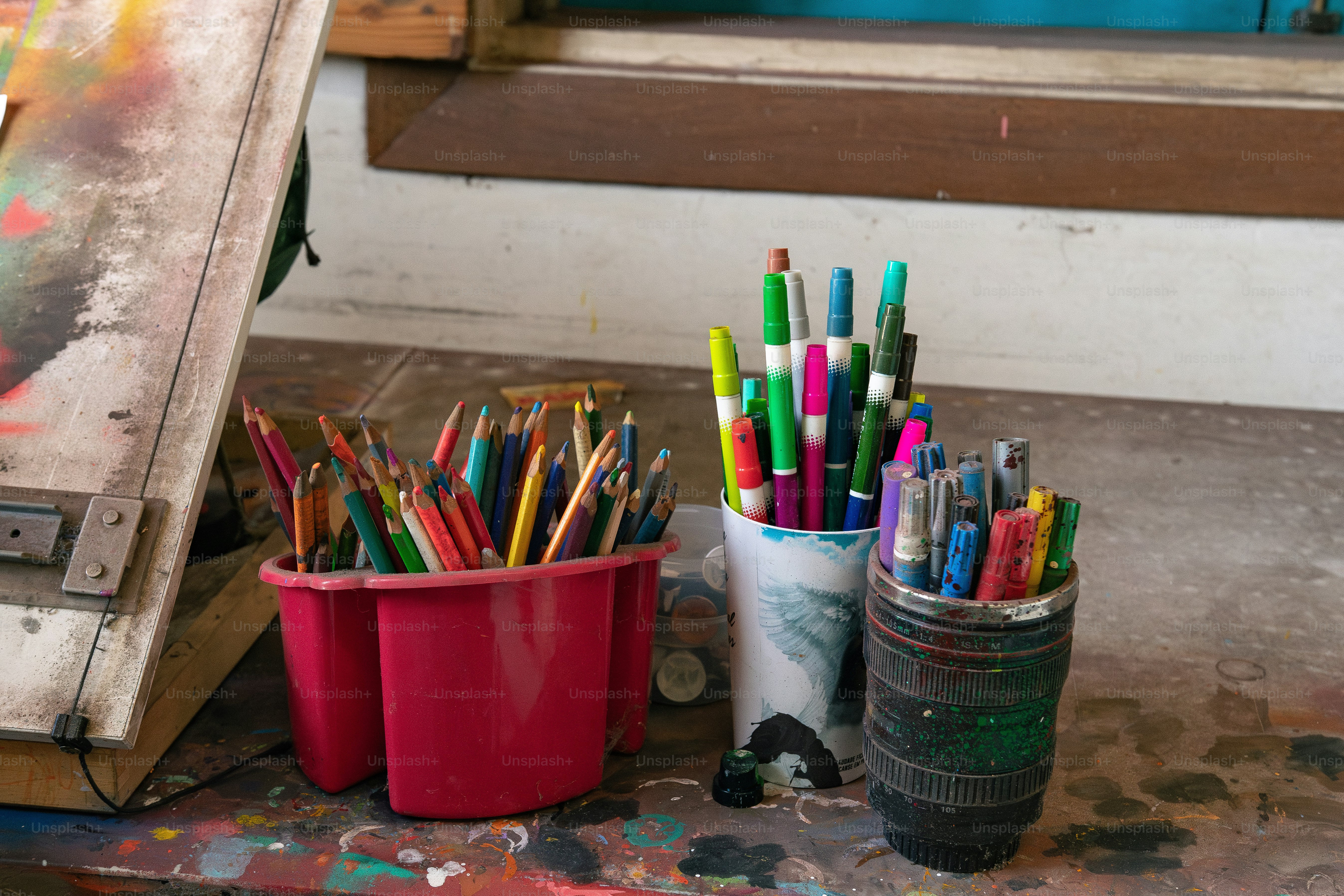 a couple of cups filled with lots of colored pencils