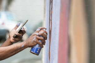 a person holding a spray bottle and a cell phone