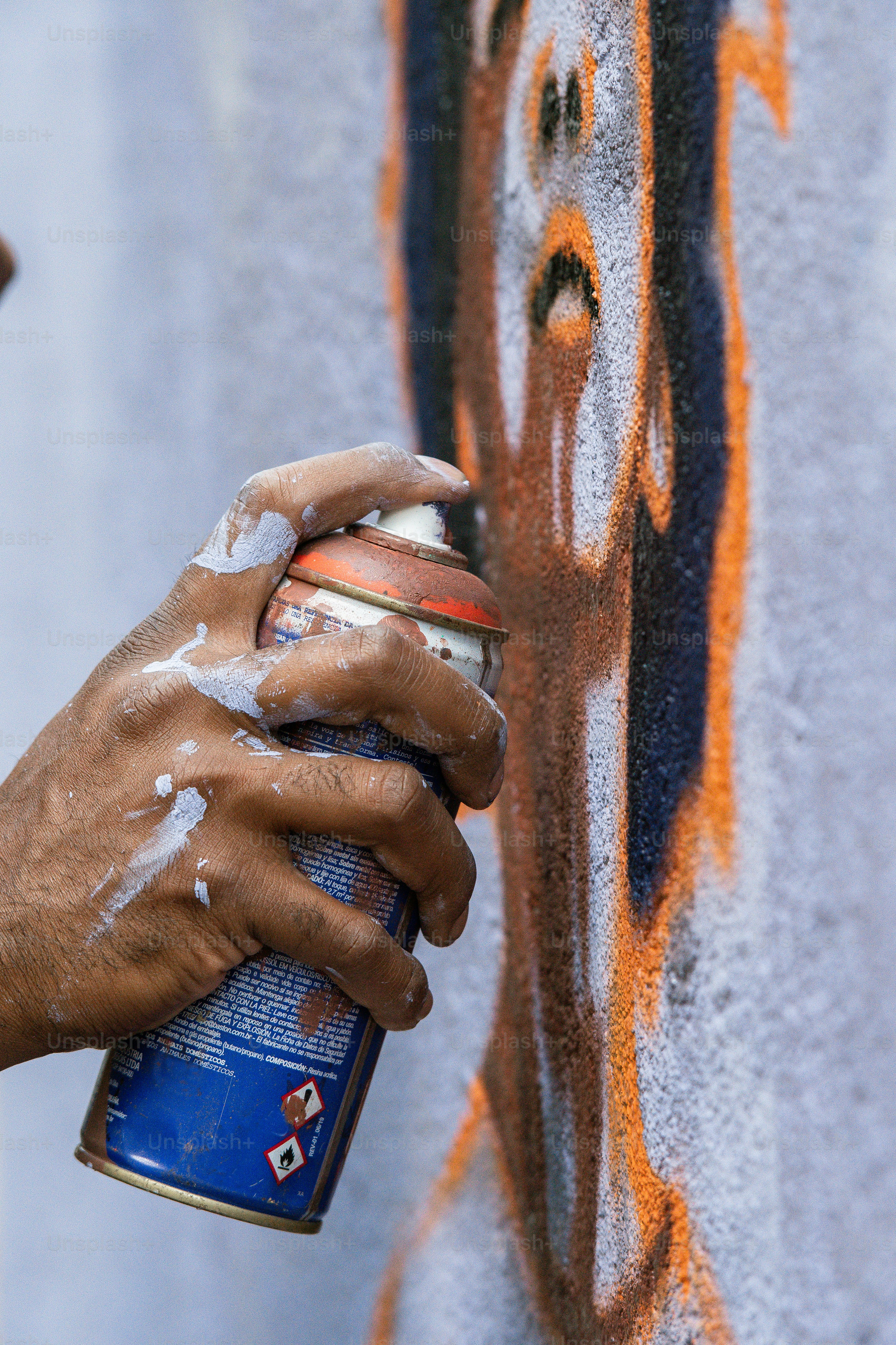 a person spray painting a wall with graffiti