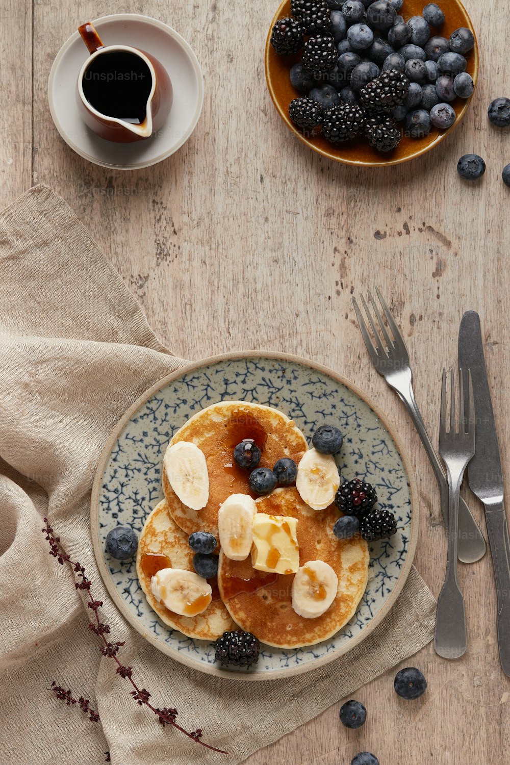 a plate of pancakes topped with bananas and blueberries
