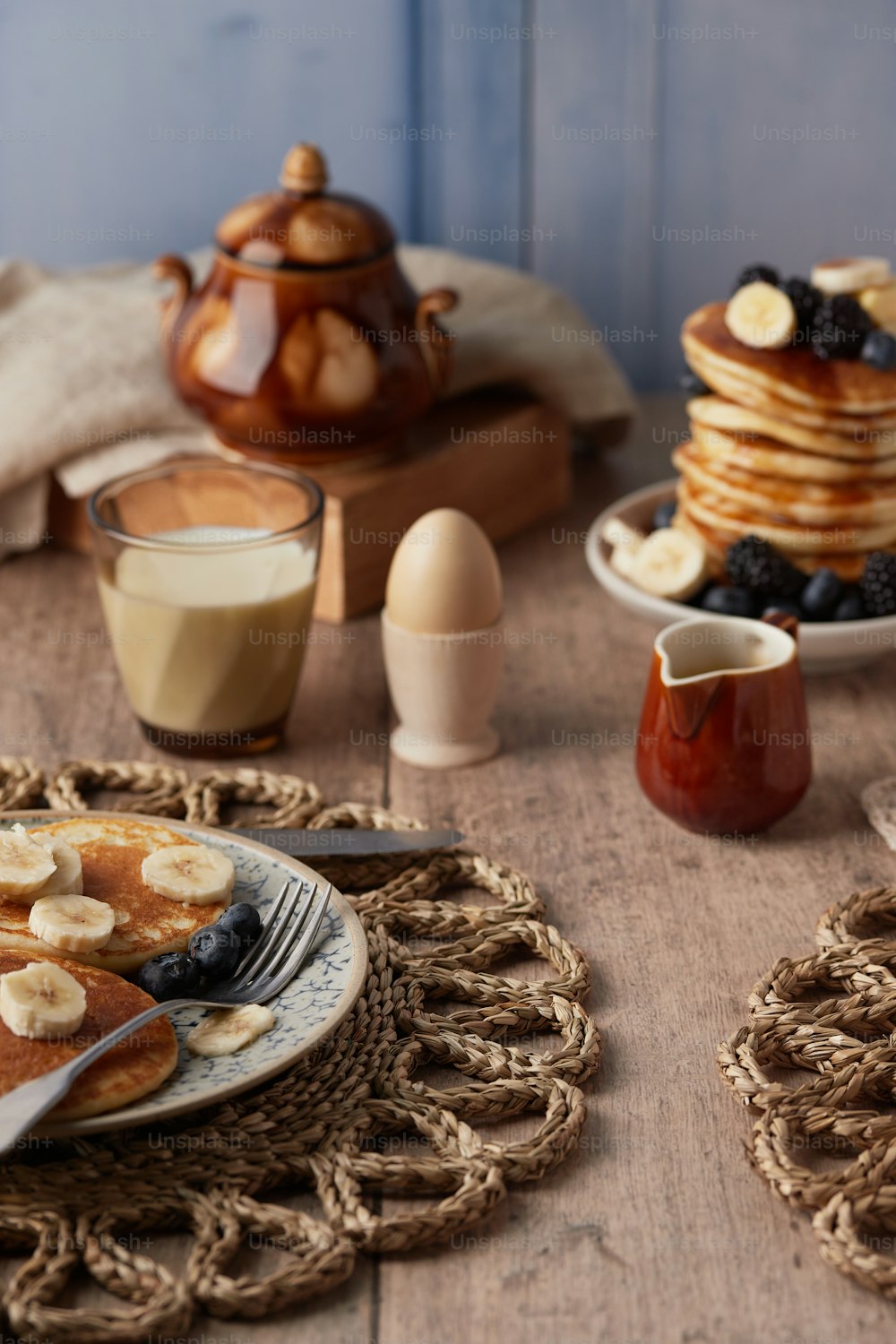 a table topped with pancakes and fruit on top of a wooden table