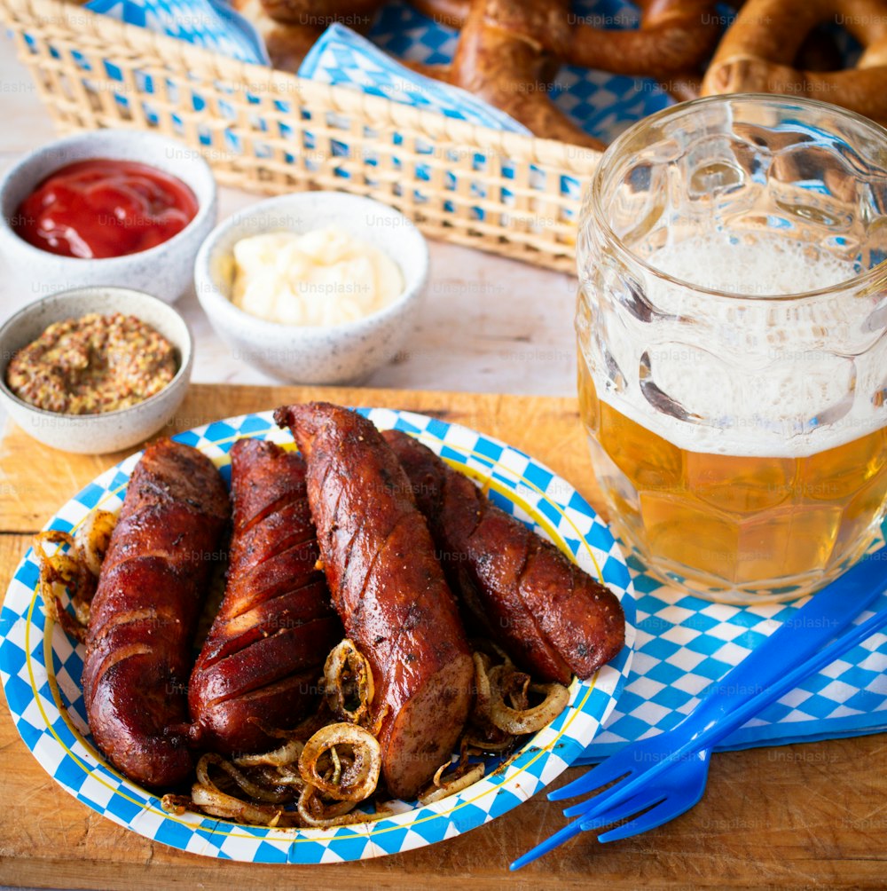 a wooden table topped with a plate of food and a glass of beer