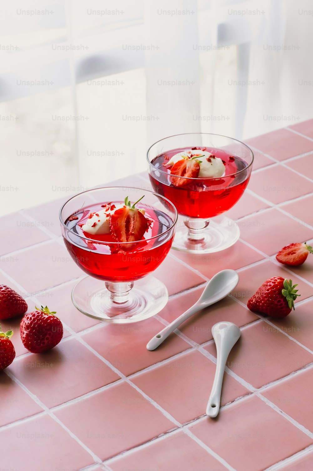 a couple of glasses filled with liquid and strawberries