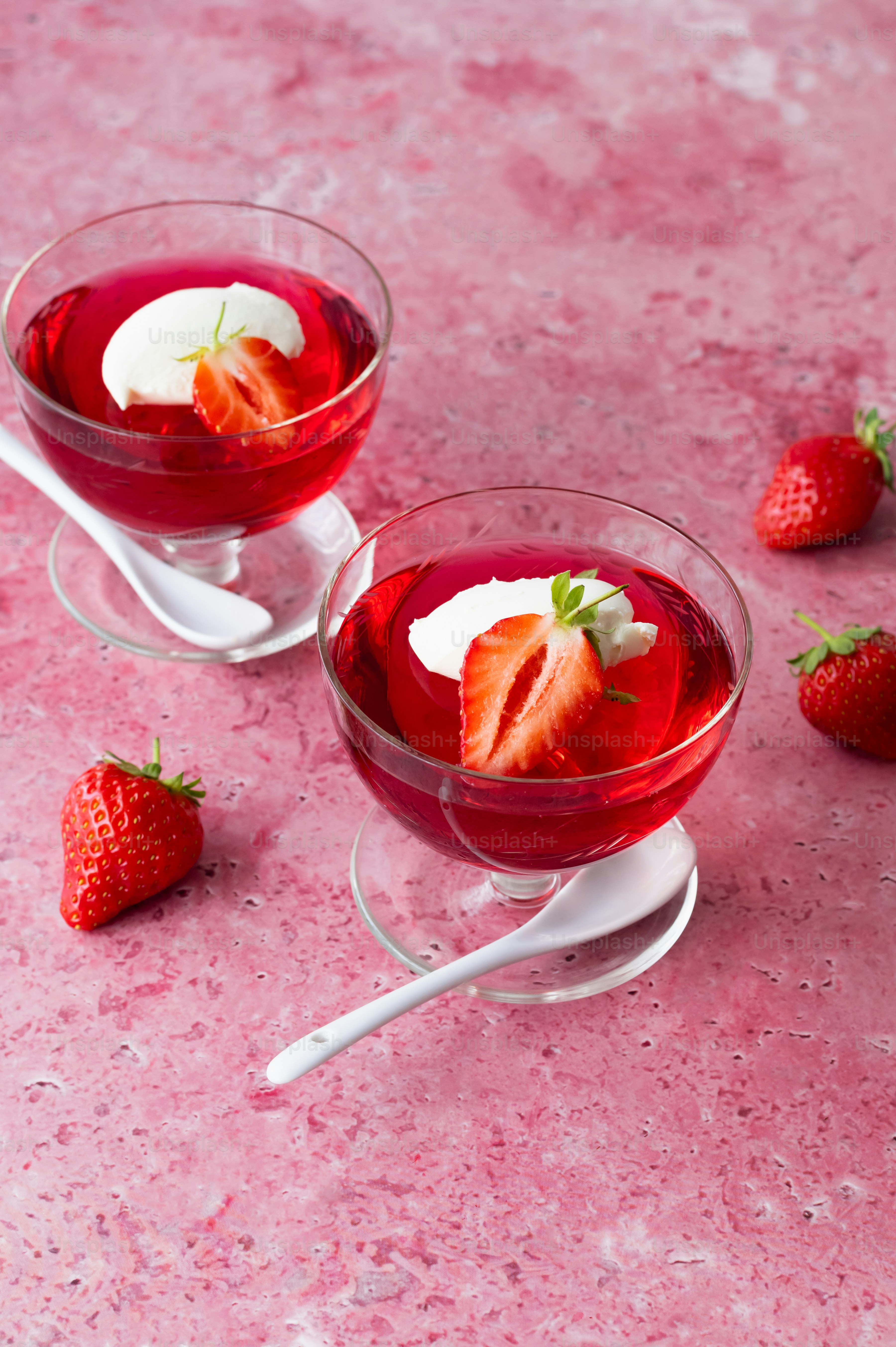 a couple of glasses filled with liquid and strawberries