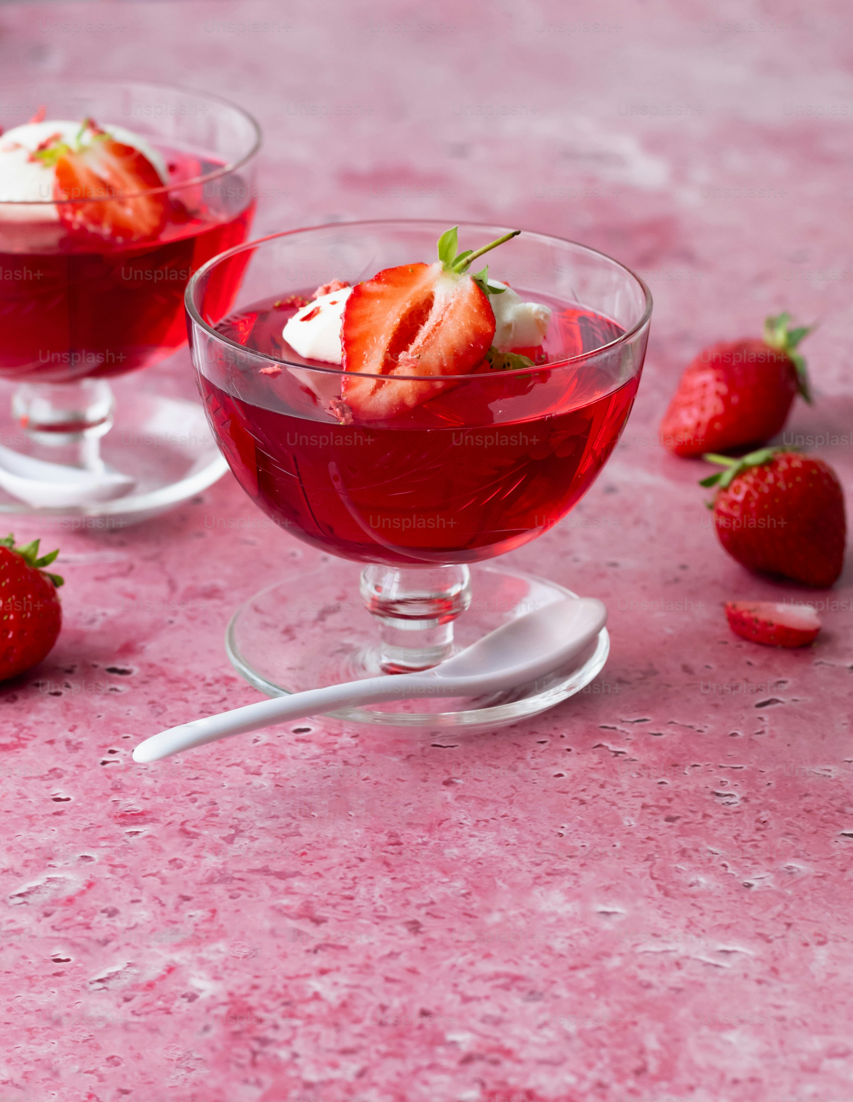 a couple of glasses filled with liquid and strawberries