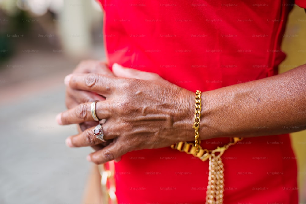 a close up of a person wearing a gold chain bracelet