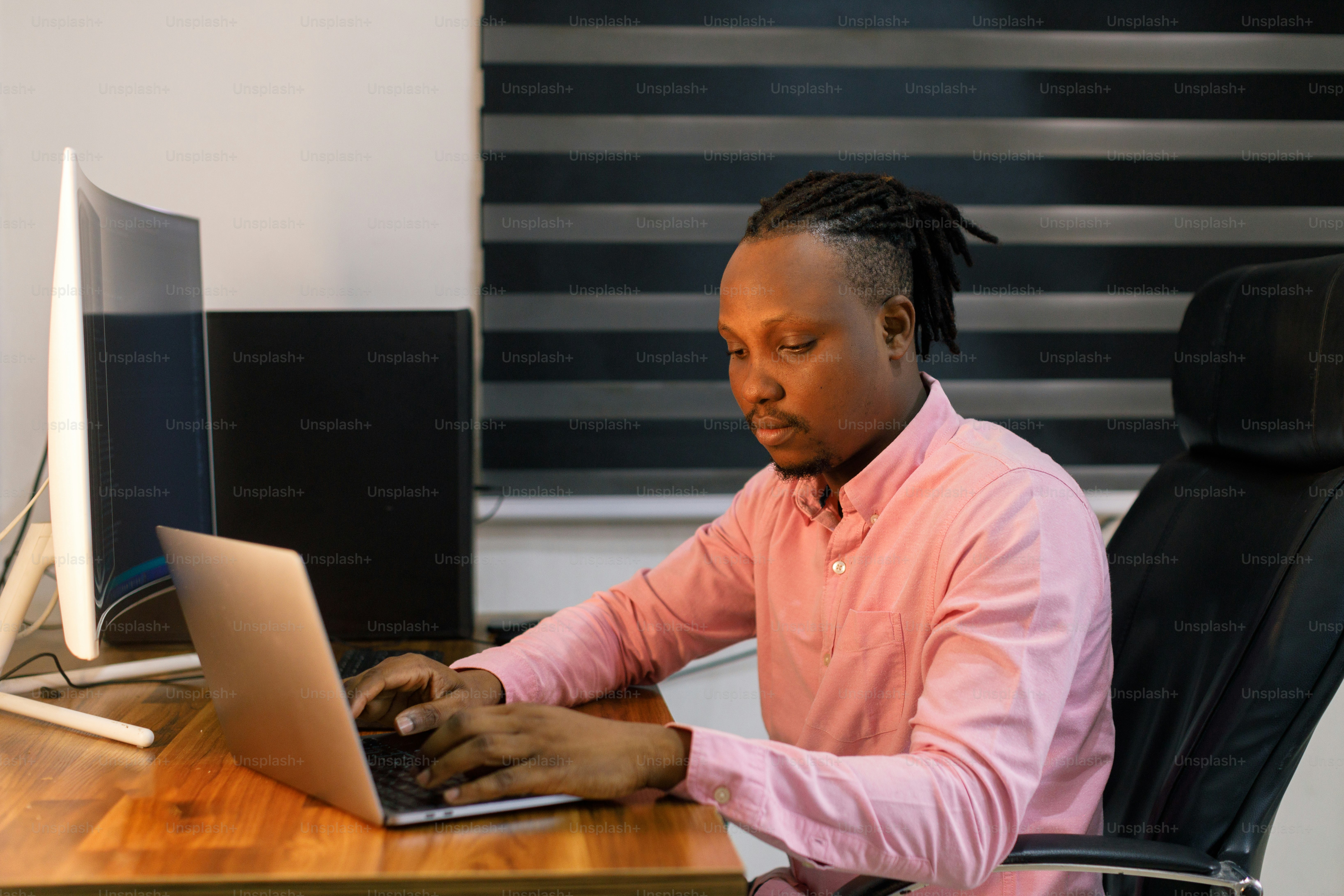 책상에 앉아 노트북 컴퓨터를 사용하는 남자