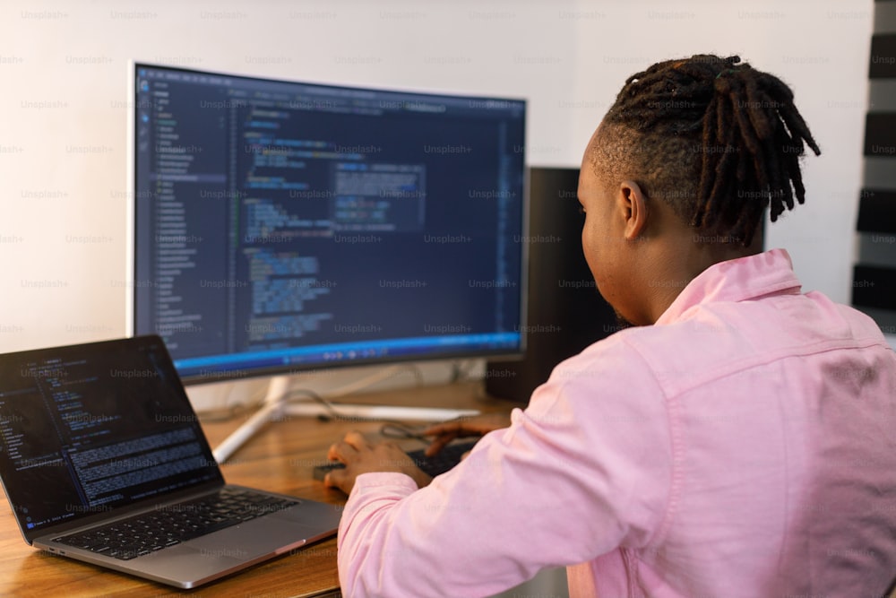 a person sitting in front of a computer on a desk