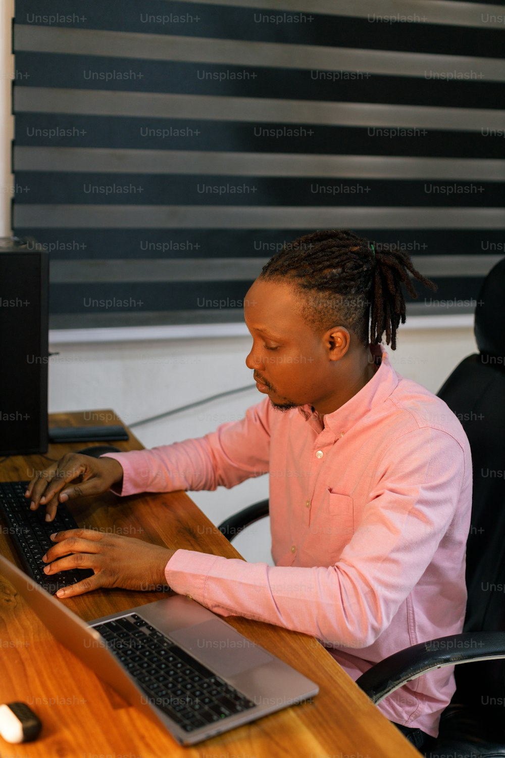 a woman sitting at a desk using a laptop computer